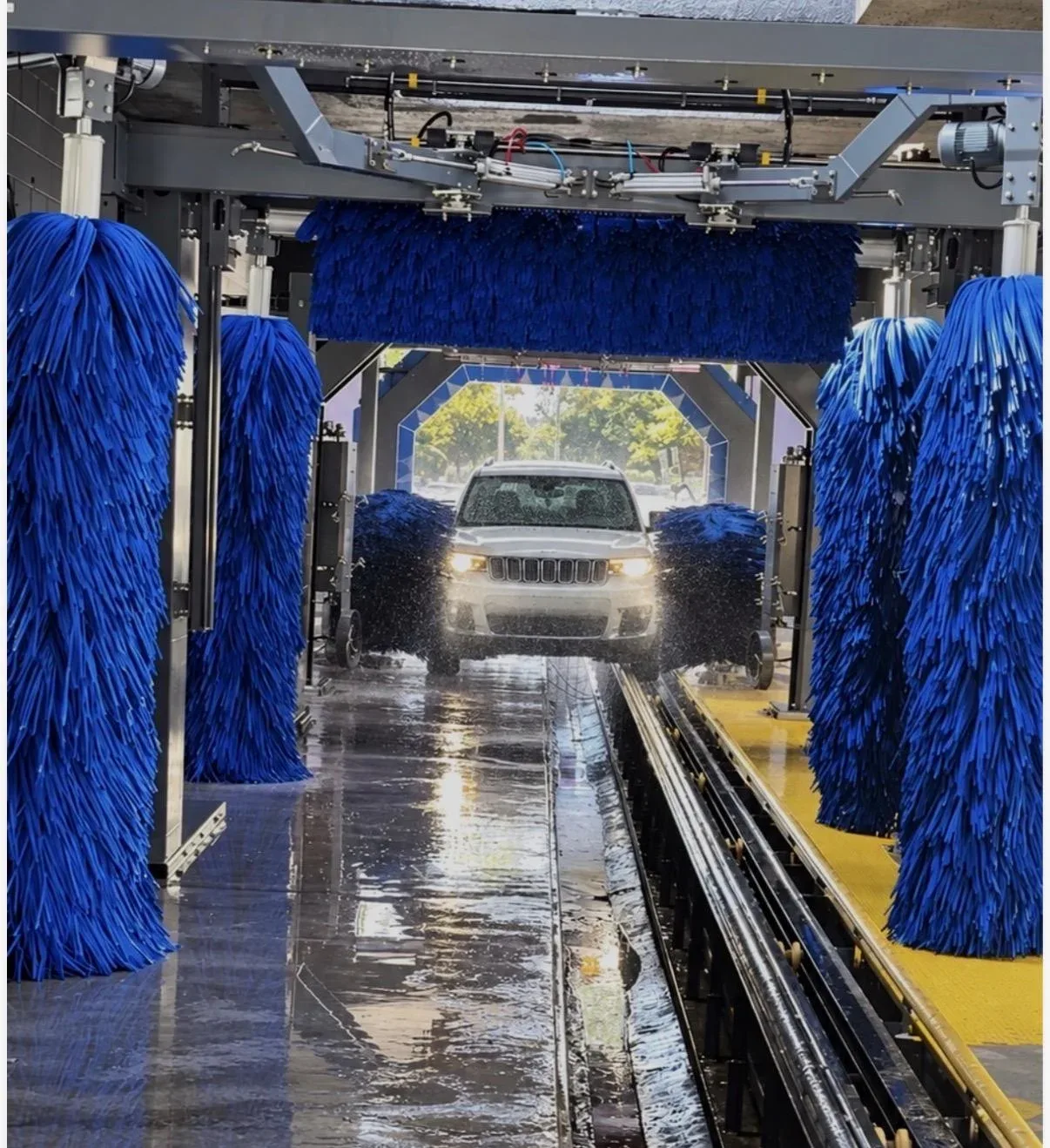 Jeep inside a car wash tunnel between blue brushes, with an Orlando label